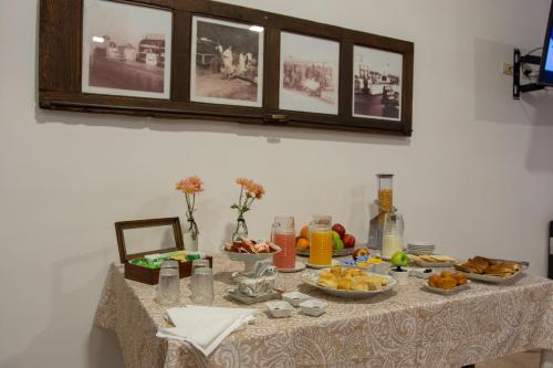 un tavolo con sopra del cibo con delle foto sul muro di Hotel del Ingenio a Libertador General San Martín