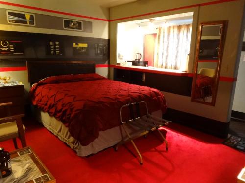 a bedroom with a red bed and a mirror at The Star Trek - USS Enterprise Room at the Itty Bitty Inn in North Bend