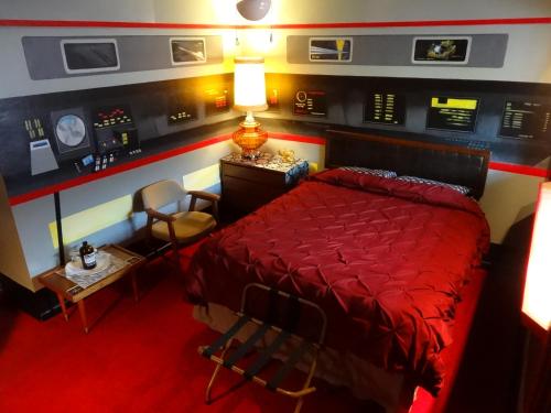 a bedroom with a red bed and a table and chairs at The Star Trek - USS Enterprise Room at the Itty Bitty Inn in North Bend