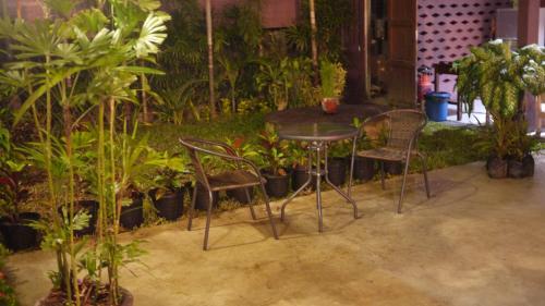 a table and chairs in a room with plants at Baan Jaru in Chiang Rai