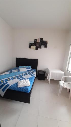 a bedroom with a bed and a cross on the wall at Hotel Zenit de Colombia in Puerto López