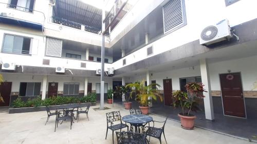 un patio con mesas y sillas en un edificio en Hotel Zenit de Colombia, en Puerto López