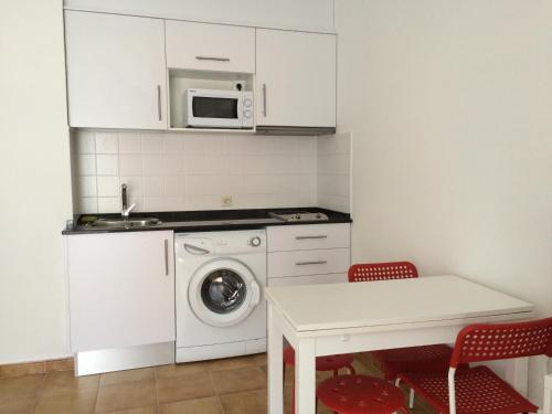 een keuken met een wasmachine en een magnetron bij Studio 88 - free Parking in Lloret de Mar