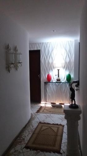 a room with a table with a lamp and two balls at CASACOMPART itapuã in Salvador