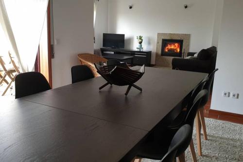 sala de estar con mesa con sillas y chimenea en Carminho beach house, en Vila do Conde
