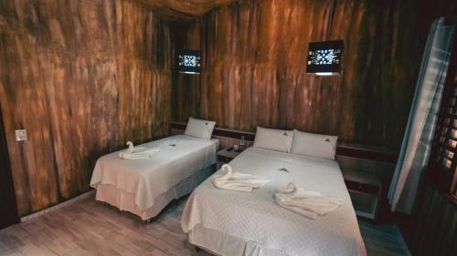 a room with two beds with towels on them at Pousada Pedra Grande in Morros