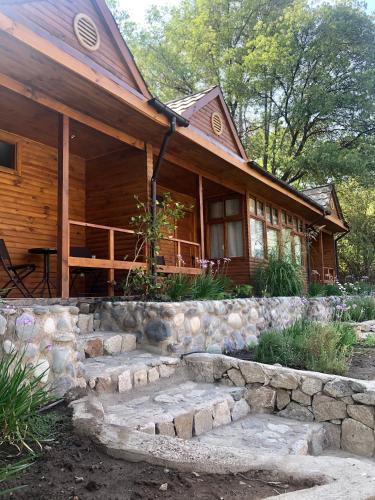 a log cabin with a stone path in front of it at Refugio del Maipo Lodge in San José de Maipo