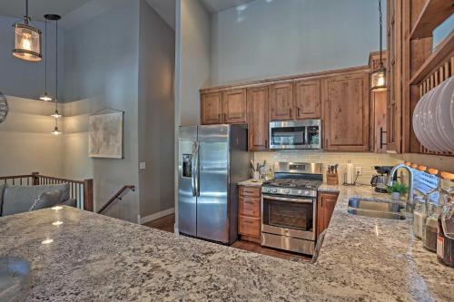 a kitchen with stainless steel appliances and wooden cabinets at Lead Family Home with Hot Tub, 2 Mi to Deer Mountain in Lead