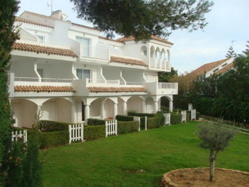 a large white house with a green yard at APCOSTAS - Complejo Al Andalus in Alcossebre