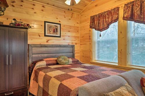 ein Schlafzimmer mit einem Bett in einem Blockhaus in der Unterkunft Cozy Heber Springs Cabin with Deck and Dock! in Heber Springs