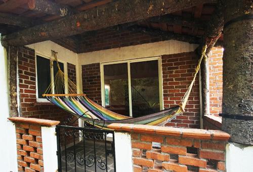 a hammock is hanging on a porch at Senda Monarca in Senguio