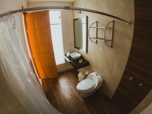 y baño con aseo, lavabo y espejo. en Villa Oasis en Ica