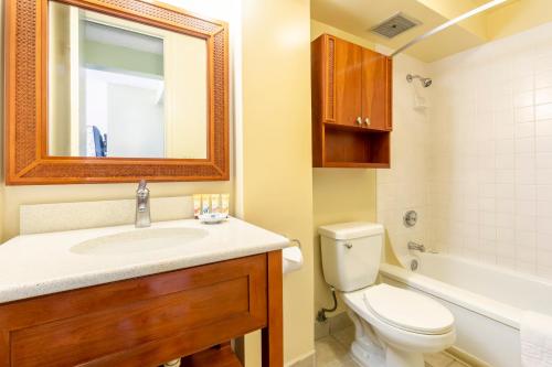 ein Badezimmer mit einem Waschbecken, einem WC und einem Spiegel in der Unterkunft Pacific Monarch Hotel in Honolulu