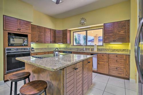 a kitchen with wooden cabinets and a sink and stools at Pool and Game Room Waterfront Harlingen Home in Harlingen
