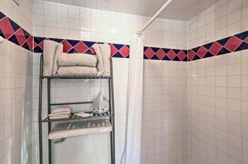 y baño con cortina de ducha y toallas. en The Quarters at Fairmount Cottage with Shared Pool en Fort Worth