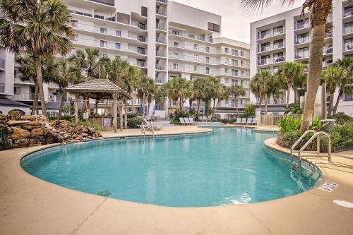 a swimming pool in a resort with palm trees and buildings at Gulf Shores Getaway with Pool, Spa and Beach Access! in Gulf Shores