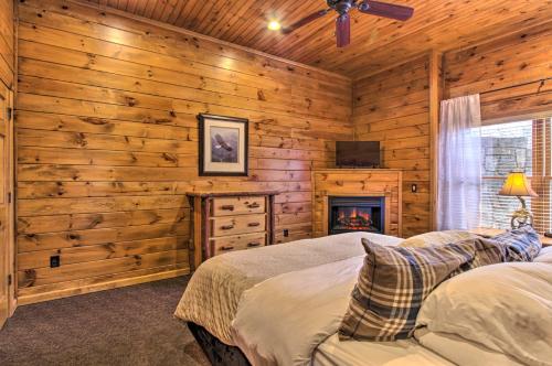 a log cabin bedroom with a fireplace and a bed at Sevierville Cabin with Hot Tub and Large Deck! in McCookville