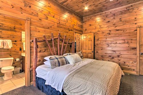 een slaapkamer met een bed in een blokhut bij Sevierville Cabin with Hot Tub and Large Deck! in McCookville