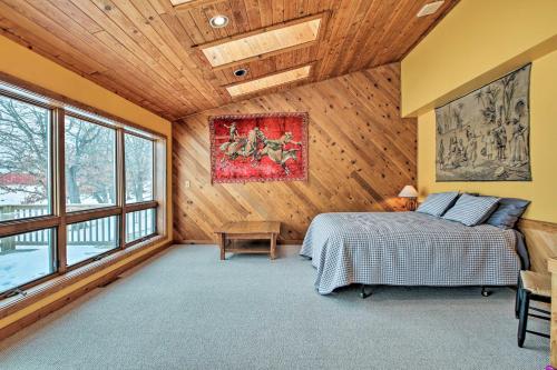 Un dormitorio con una cama en una habitación con paredes de madera. en 7-Acre Working Farm Near Lake Geneva Pets Welcome, en Burlington