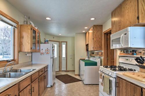a kitchen with white appliances and wooden cabinets at Cedar Cottage, Private Beach on Lake Leelanau in Cedar