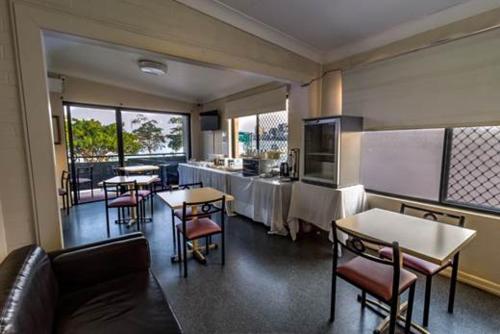 a restaurant with tables and chairs in a room at Kingsford Riverside Inn in Brisbane