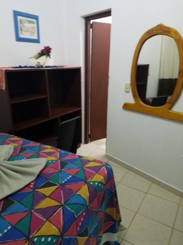 a room with a bed with a mirror and a table at B&B KeisyAlba Punta Rucia in Punta Rucia