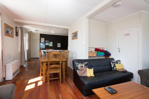a living room with a couch and a table at LKNZ Lodge & Cafe in Ohakune