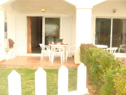 a white house with a table and chairs on the porch at APCOSTAS - Complejo Al Andalus in Alcossebre