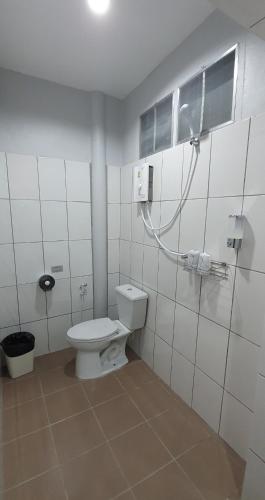 a white bathroom with a toilet and a window at Green Canyon Resort in Lamai