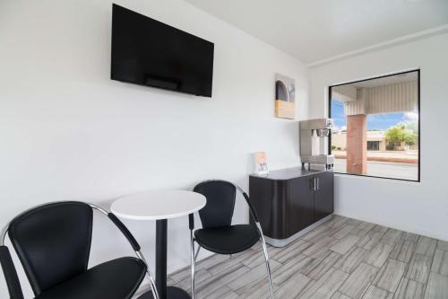 a living room with a table and chairs and a tv at Motel 6-Metropolis, IL in Metropolis