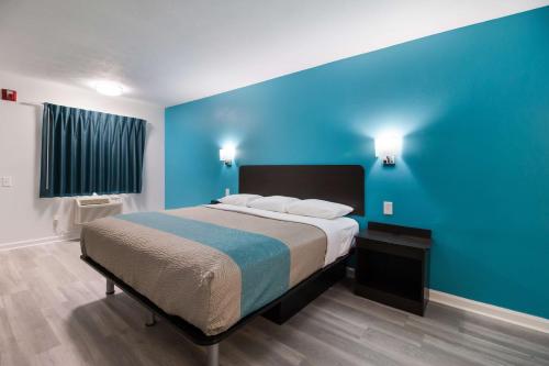 a bedroom with a large bed with a blue wall at Motel 6-Metropolis, IL in Metropolis