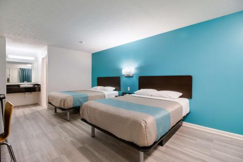 a hotel room with two beds and a blue wall at Motel 6-Metropolis, IL in Metropolis