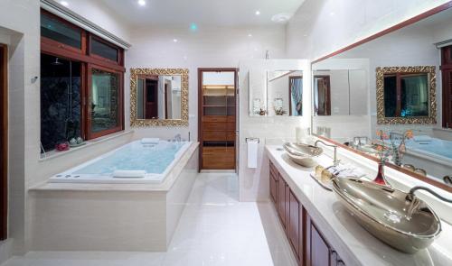 Modern Love Villa في شيانغ ماي: حمام فيه مغسلتين وحوض استحمام فيه مرايين