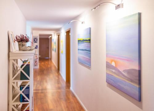 a hallway with paintings on the walls at Haus Jungnamen Sand Whg. 14 in Wittdün