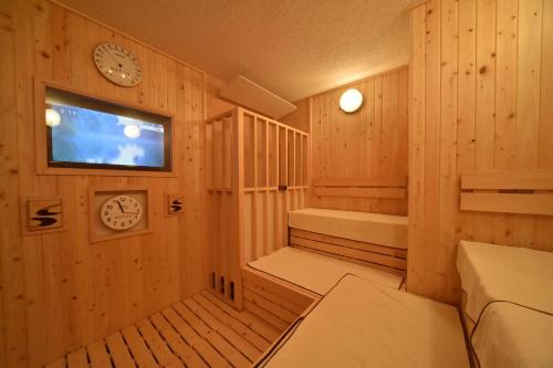 札幌的住宿－多美迎札幌 ANNEX 飯店，一间设有墙上时钟的桑拿浴室的客房