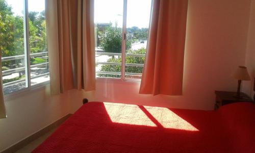 1 dormitorio con cama roja y ventana en SyS Departamento en Federación