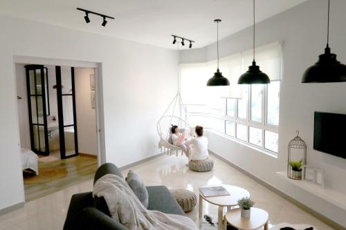 two women sitting on the floor of a living room at Octagon Ipoh by Plush in Ipoh