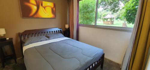 a bed in a bedroom with a large window at Green Canyon Resort in Lamai