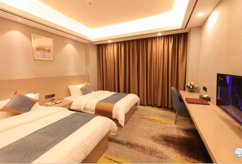 a hotel room with two beds and a flat screen tv at Five Rams City Hotel in Guangzhou
