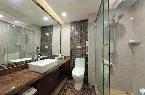 a bathroom with a toilet and a sink and a shower at Five Rams City Hotel in Guangzhou