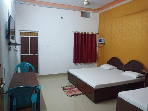 um quarto com uma cama e uma cortina vermelha em vindhyvasini guest house em Kushinagar