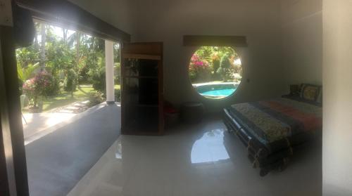 a bedroom with a bed and a window with a pool at Villa Rizki Candidasa in Candidasa
