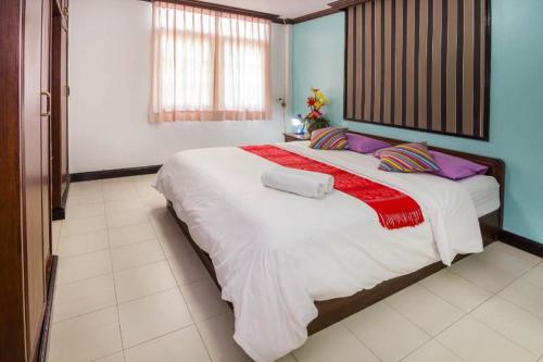 a large bedroom with a large bed with purple pillows at Villa Rosa with Private Pool and Jacuzzi 100m to beach in Pattaya South
