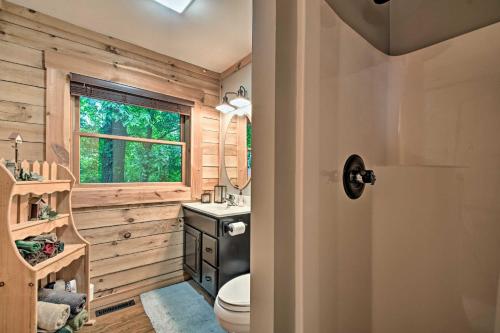 a bathroom with a toilet and a window at Cozy Amish Country Cabin on Shipshewana Lake! in Shipshewana