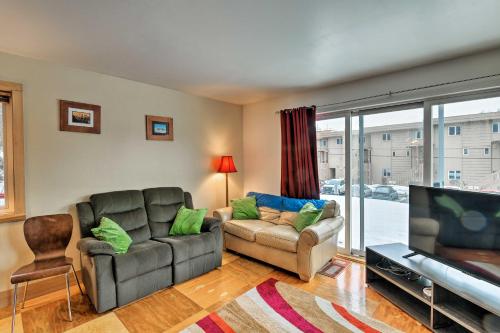 a living room with a couch and a flat screen tv at Walk to Town and Coast Anchorage Condo with Fireplace in Anchorage