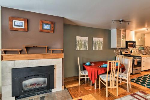a living room with a fireplace and a table and chairs at Walk to Town and Coast Anchorage Condo with Fireplace in Anchorage
