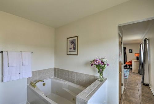 een badkamer met een bad en een vaas met bloemen bij Elgin Home with Mountain Views about 3 Miles to Wineries in Elgin