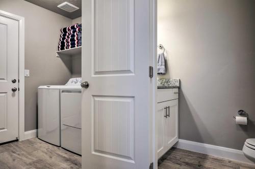 un baño con una puerta que conduce a una lavandería en Utah Home with Pool Access Near St George and Zion!, en Washington