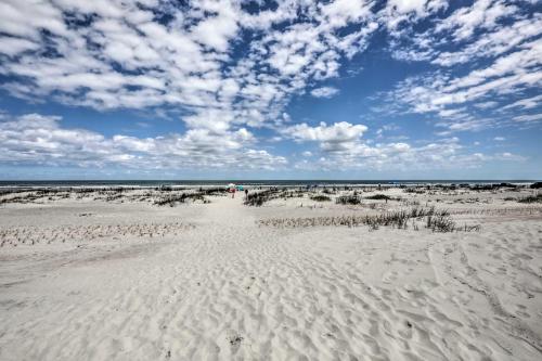 a beach with a person walking on the sand at Beachside St Augustine Resort Condo, 6 Mi to Dtwn! in Coquina Gables