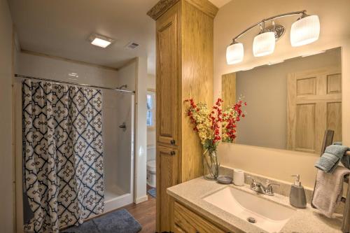 La salle de bains est pourvue d'un lavabo et d'une douche avec un vase de fleurs. dans l'établissement Waterfront Cabin with Hot Tub on Tuckasegee River!, à Bryson City